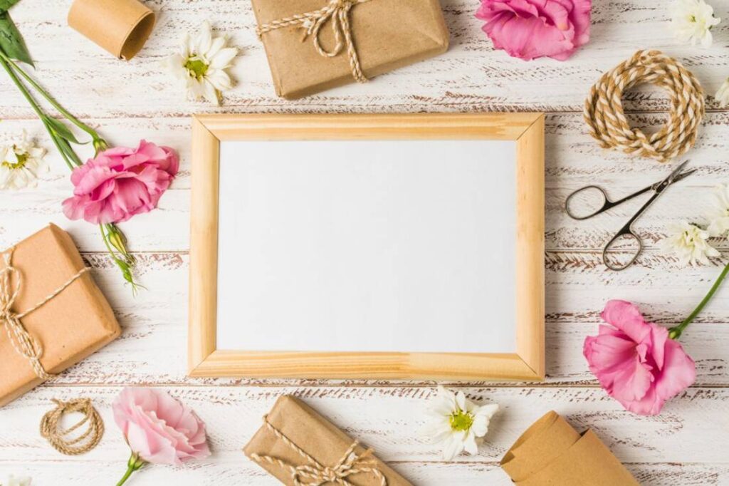 A blank wooden frame surrounded by pink flowers.