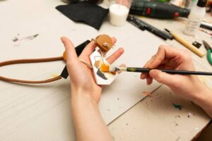 A person paints a handmade object.