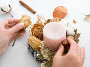 A person's hands arranging dried flowers.
