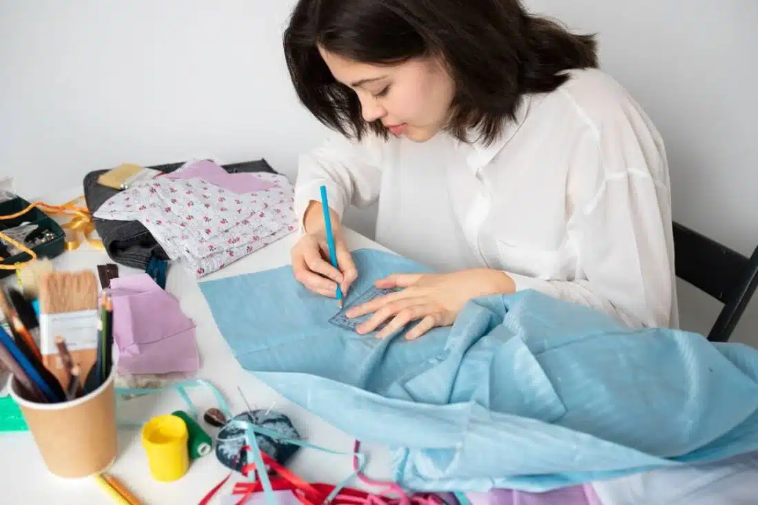 A person in a white shirt designs clothing.